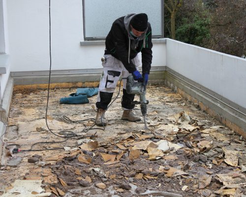 Utilisation d'un marteau-piqueur sur un toit terrasse
