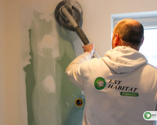 Utilisation d'une ponceuse sur un mur
